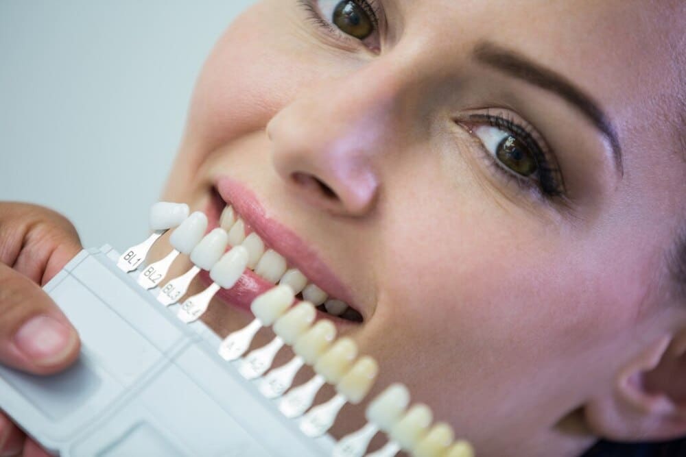 dentista examina paciente femenino tonos dientes