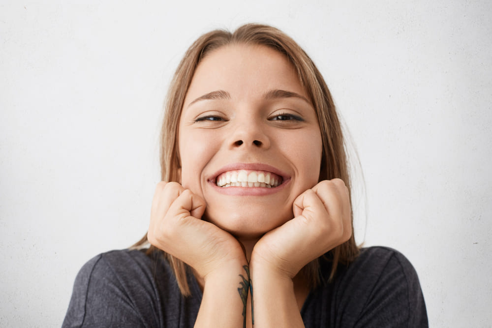 mujer joven emocionada feliz cerca amplia sonrisa alegre